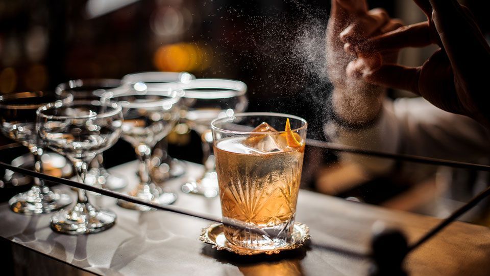Préparation d’un cocktail signature au bar Maison Amour à Tours, avec vaporisation d’agrumes et verres prêts à servir